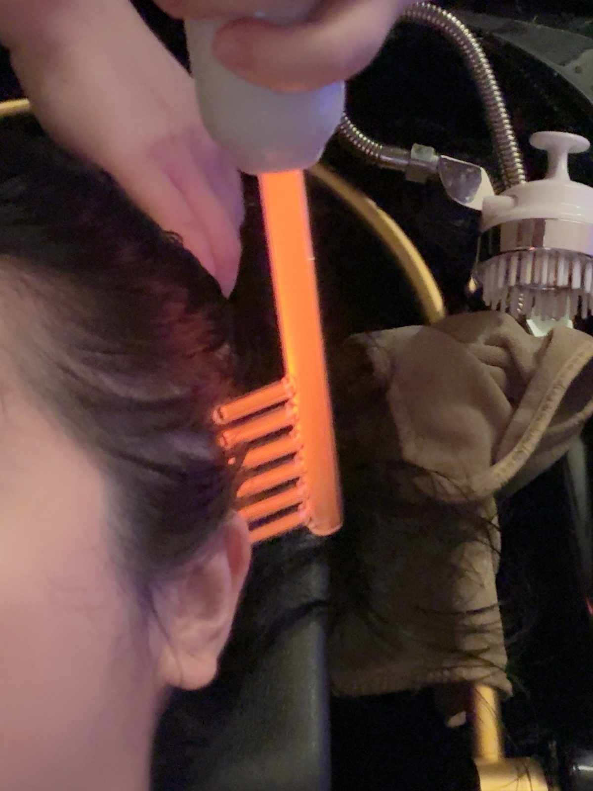 Sonic purification comb on scalp closeup